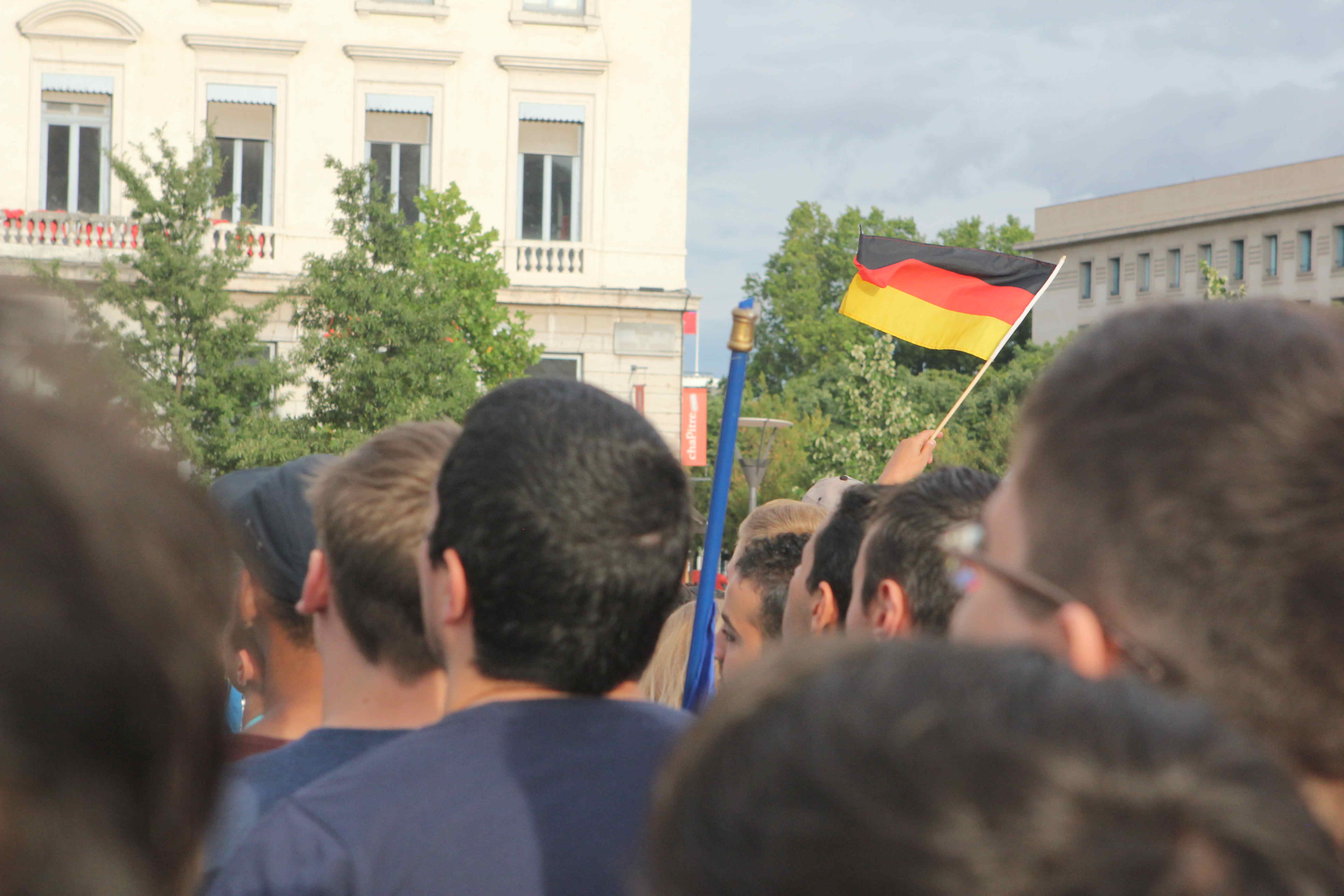 Un couple de retraités allemands agite un fanion plce Bellecour