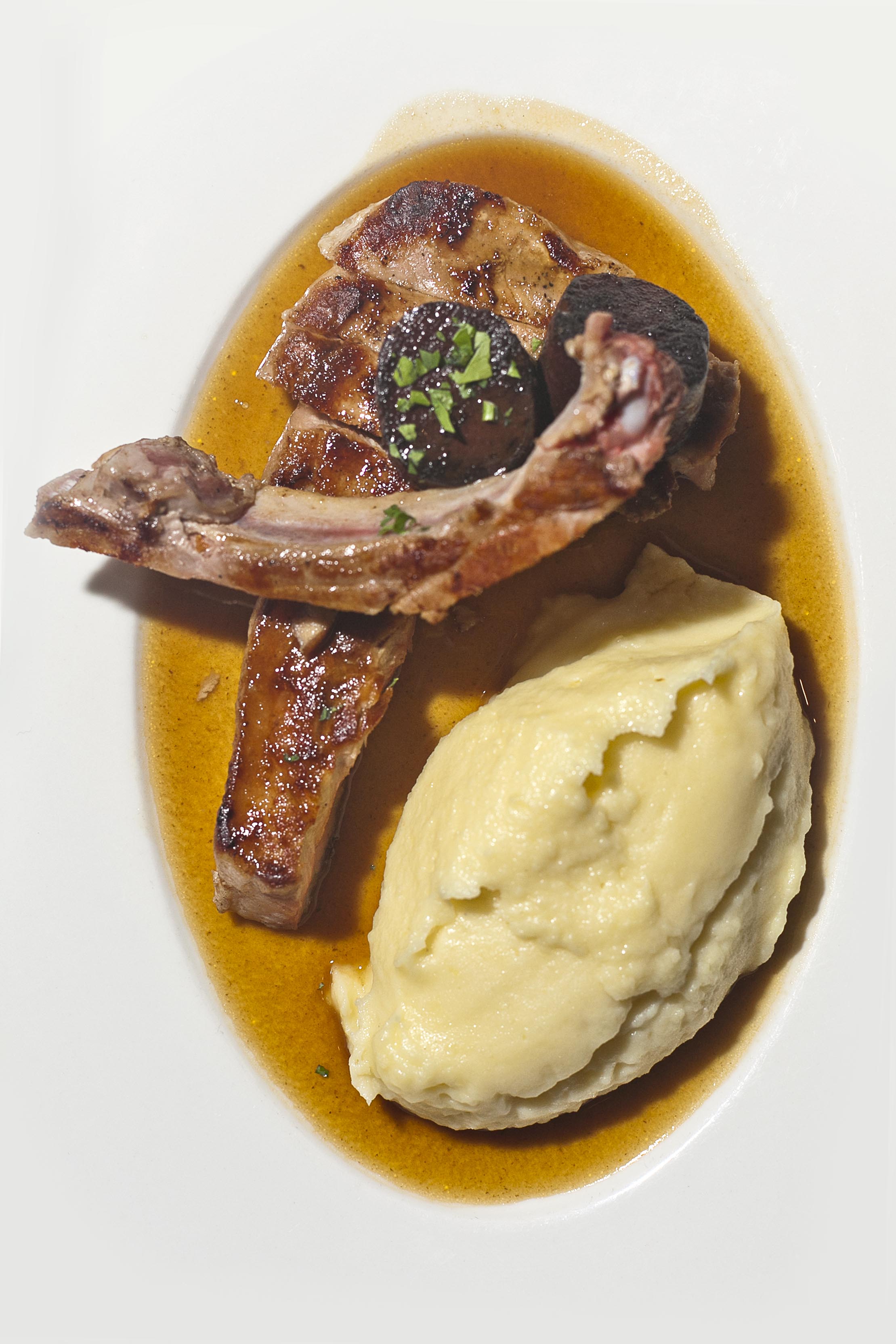 Côte de cochon fermier du Cantal cuit en culotte, avec sa pomme purée maison, son boudin noir, sans oublier le très régressif jus de cochon.