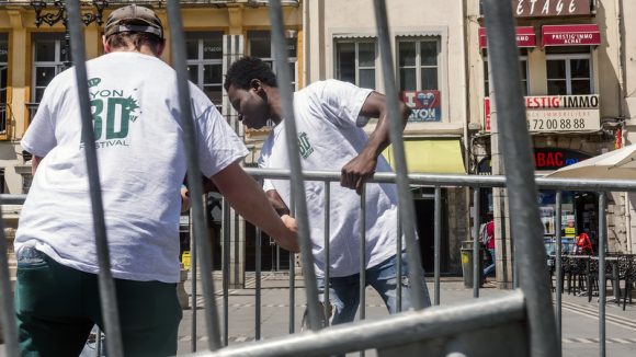 Un duo bénévole-réfugié en plein montage du festival Lyon BD © Tim Douet – juin 2018