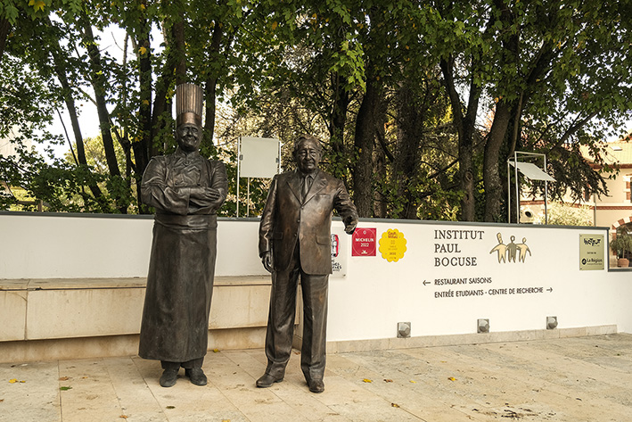 Les statues de Paul Bocuse et de Gérard Pélisson. Tous deux sont à l’origine de l’École nationale des arts culinaires devenue l’institut Paul-Bocuse