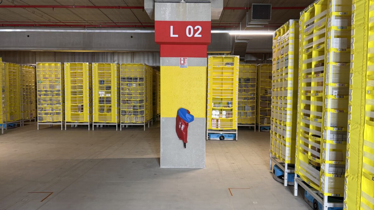 Des robots bleus, appelés drives, portent et rangent les colis.